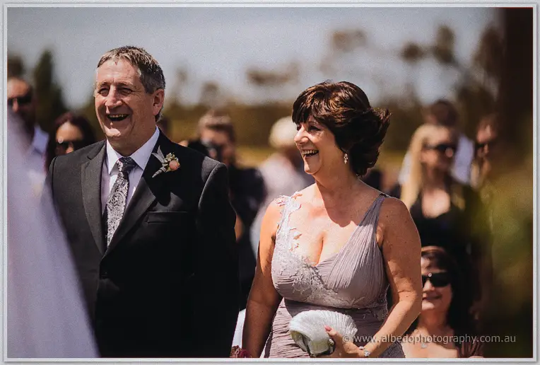 Steph's father and mother laugh warmly while walking together after the ceremony handover.