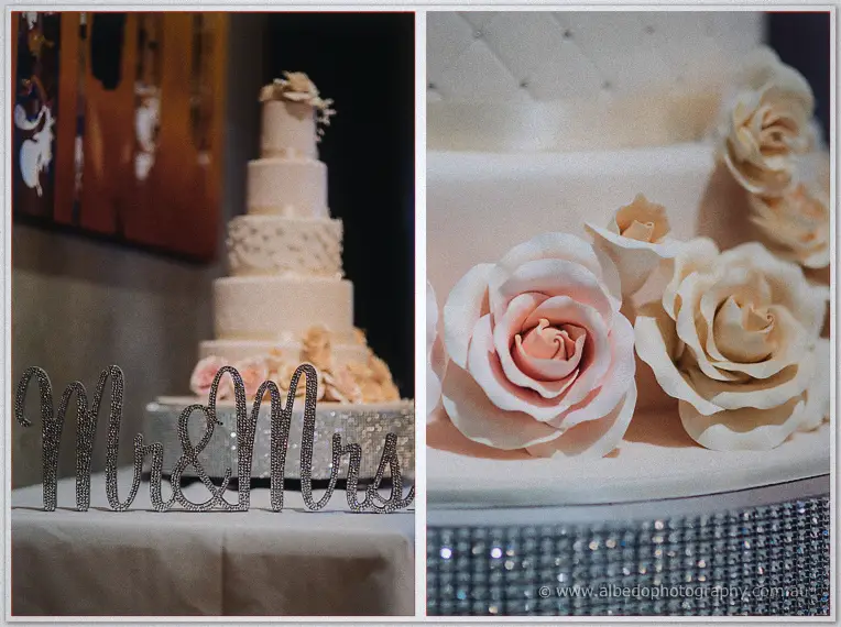 Blush tiered wedding cake with a sparkling Mr and Mrs sign and sugar roses in close-up