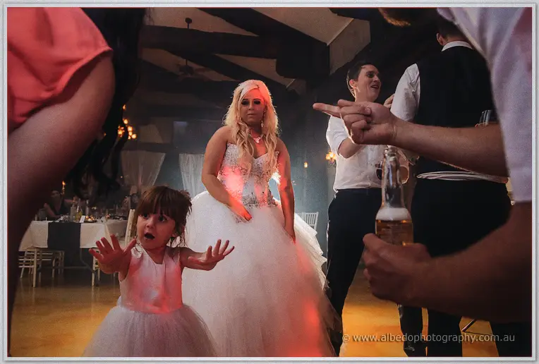 Steph dancing with her little flower girl on the packed, warmly lit dance floor