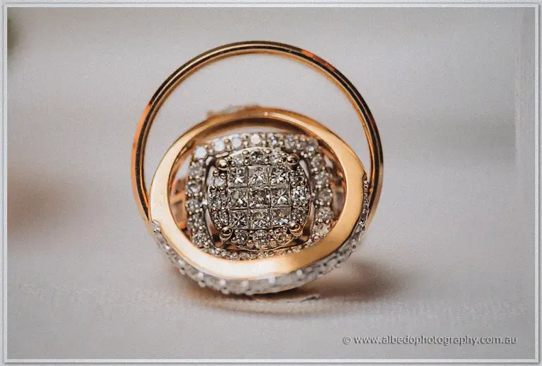 Macro view of Steph's rose-gold engagement ring with its sparkling diamond cluster centre