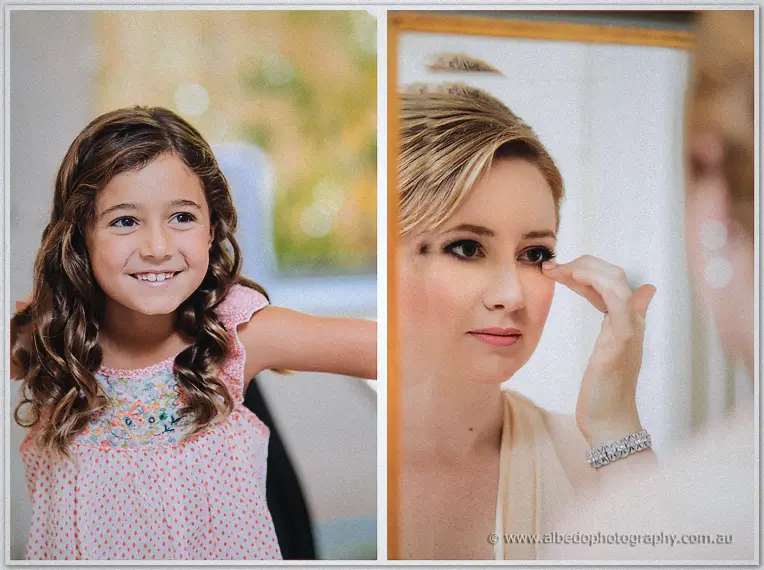 A curly-haired flower girl in pink polka dots beams; Elena dabs concealer at the mirror