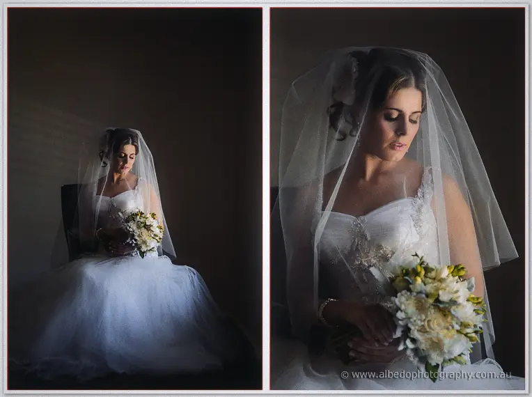 Seated Elena wrapped in tulle holds her ivory bouquet, front view then veiled close-up
