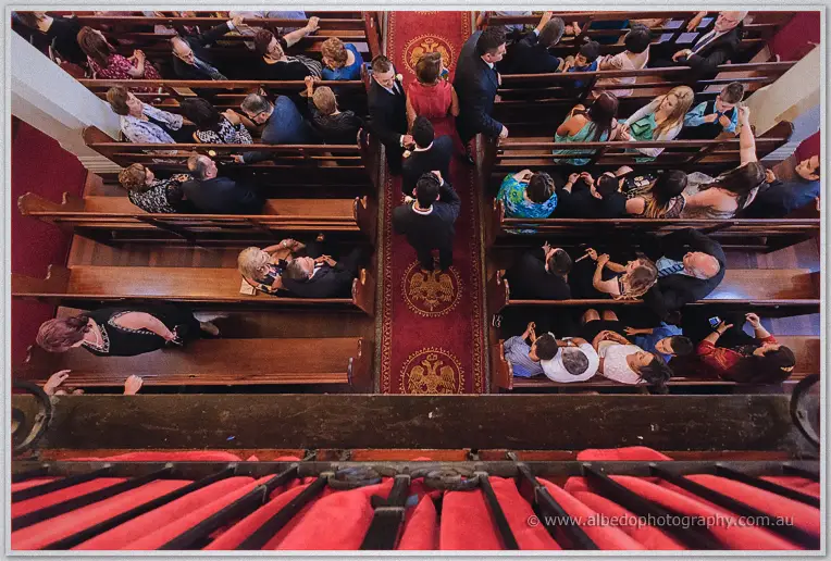 Overhead view of the red eagle aisle runner between pews packed with wedding guests