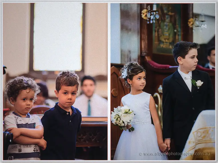 Two boys watch from the pews, then the flower girl holds hands with her young escort