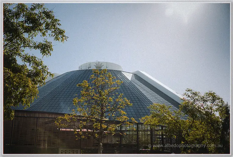 Sunlight glints off the vast glass dome of the Perth concert hall, framed by leafy green trees