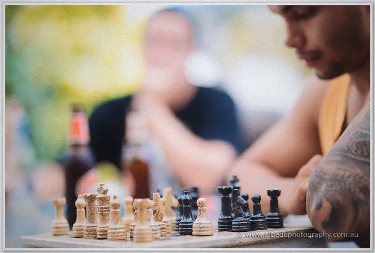Groomsmen play a laid-back game of chess over beers in the garden before the ceremony