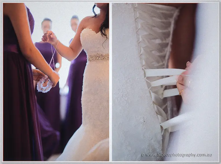Bridesmaid in plum purple holds a beaded bracelet beside Haley's strapless lace gown in soft window light