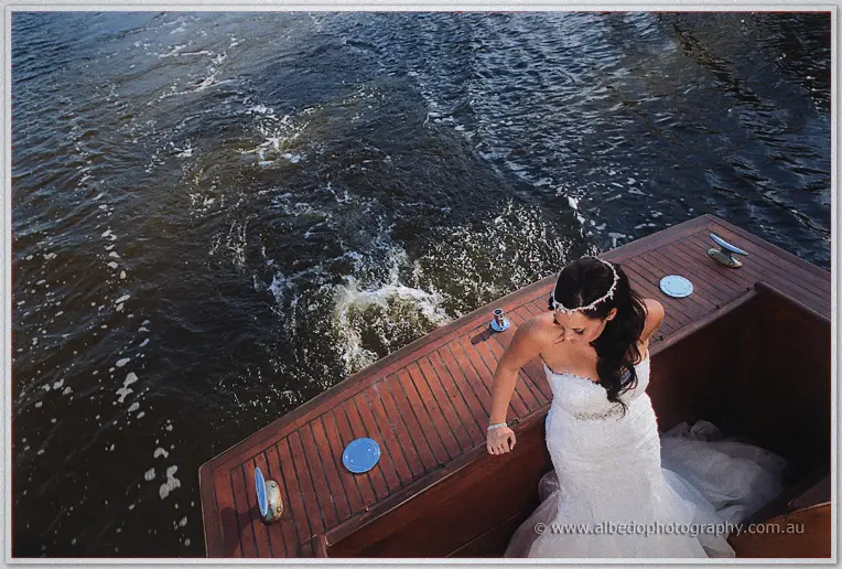 Haley leans on the warm stern deck from above as the cruiser's wake curls through dark river water