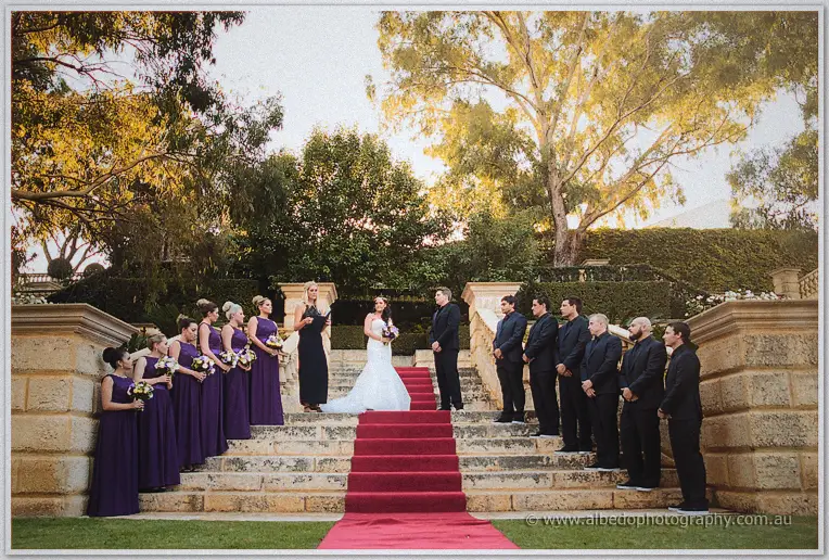 Haley and Matt exchange vows on carpeted steps flanked by their bridal party at golden hour