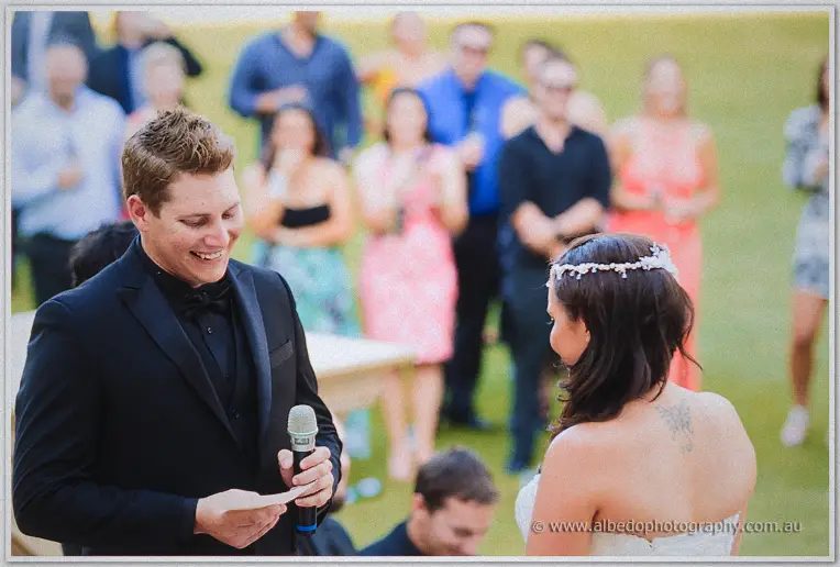 Matt laughs into the microphone while reading his vows to Haley before their gathered guests