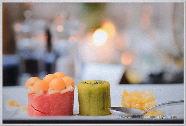 Fruit dessert of watermelon, melon balls and kiwi plated with diced pineapple at the reception