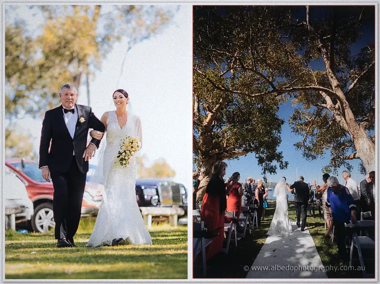 Stacey walks the aisle with her father past seated guests toward the riverside arch.