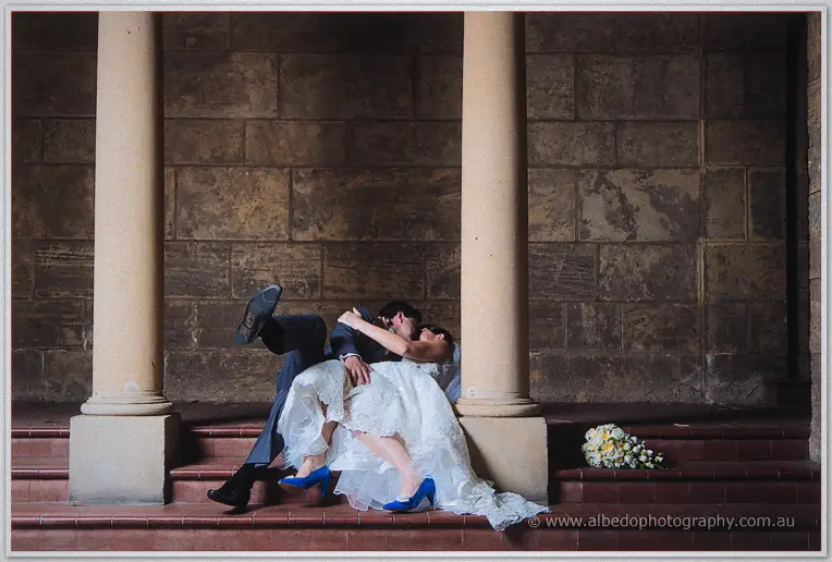 Nathain dips Stacey for a kiss on the tiled steps, bouquet waiting on the ledge.