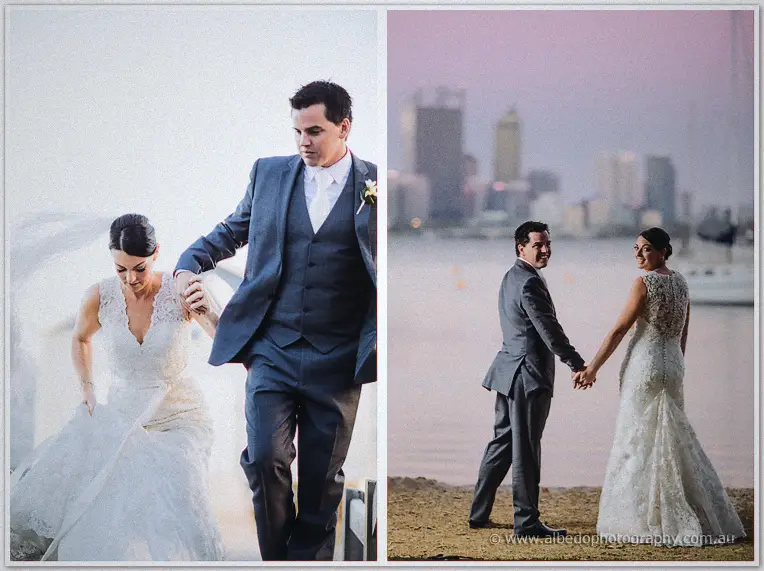 The groom helps his bride up from the shore, then they walk the sand with the skyline hazy behind.