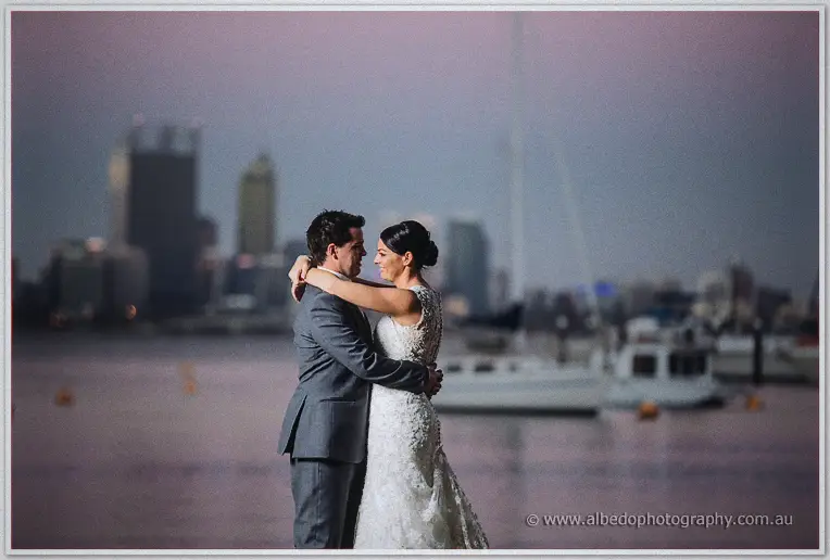 Wrapped in each other's arms by the bay, the couple gaze into each other's eyes at dusk.