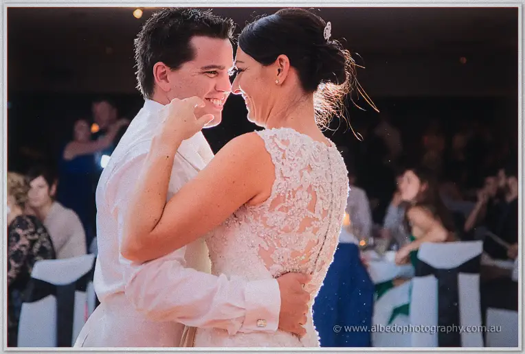 Forehead to forehead, Stacey and Nathain sway on the dance floor among seated guests.