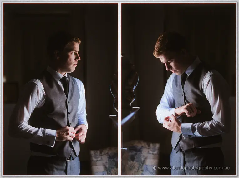 Moody window-lit frames of a groomsman buttoning his grey waistcoat in a dim dressing room