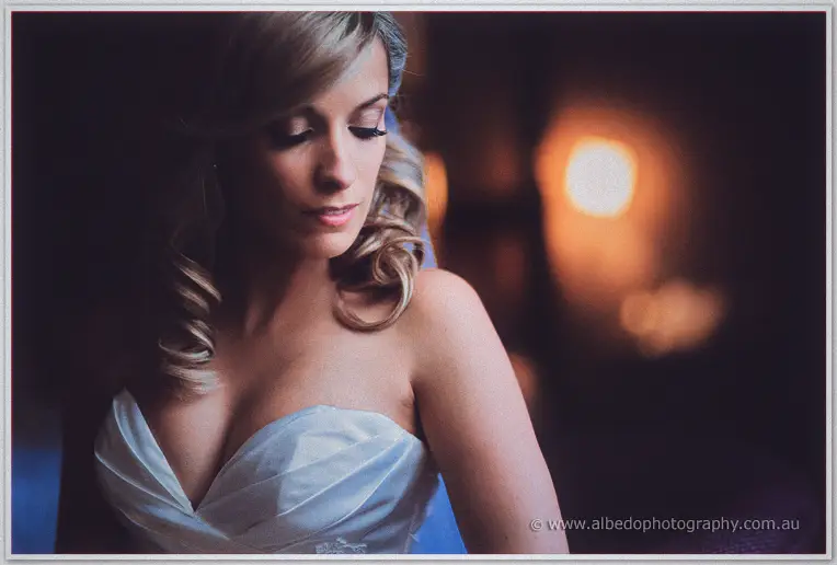 Soft-lit portrait of Cristina in her strapless gown, curls over one shoulder