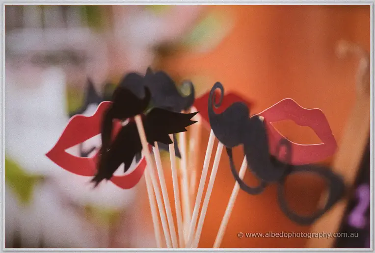 Paper lips, moustaches and glasses on sticks wait in a bunch for photobooth antics at the reception