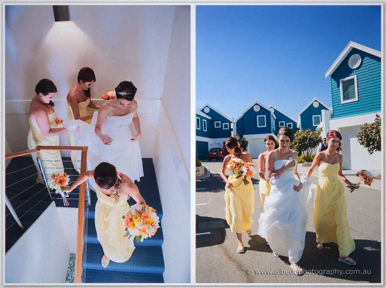 Bridesmaids carry bouquets down stairs, then walk Elisha past blue beach houses in the sun