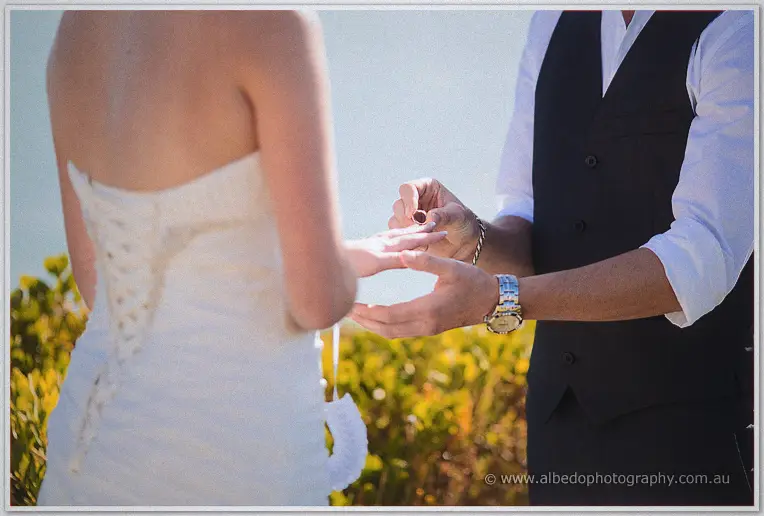 Shane slides the ring onto Elisha's finger in a close-up of the vow moment