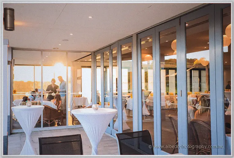 Sunset spills through glass doors onto cocktail tables at The Cut's reception terrace