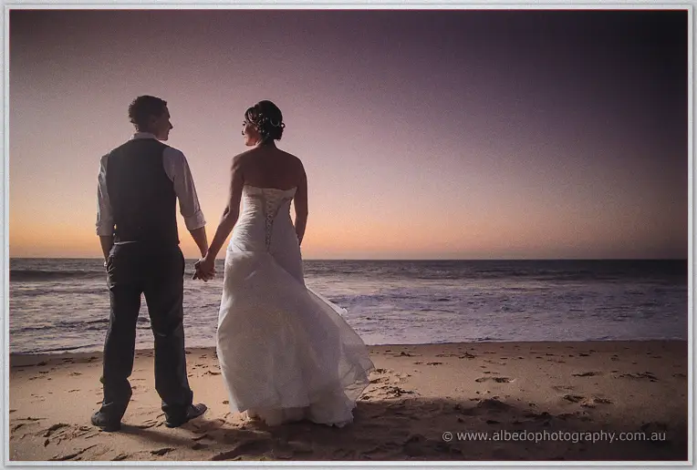Elisha and Shane face the darkening surf hand in hand on the empty beach