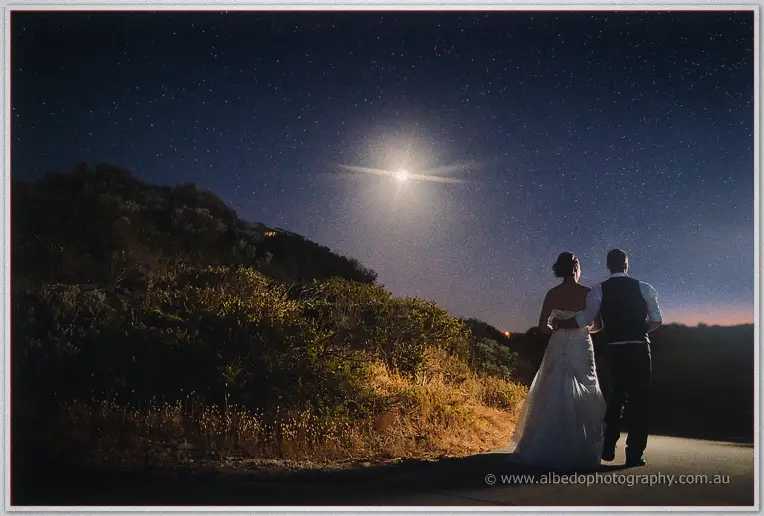 Bride and groom stroll away up a moonlit path under a star-filled sky at The Cut