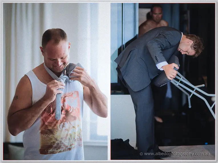 Candid side-by-side of a groomsman knotting his tie and another folding a chair in his suit