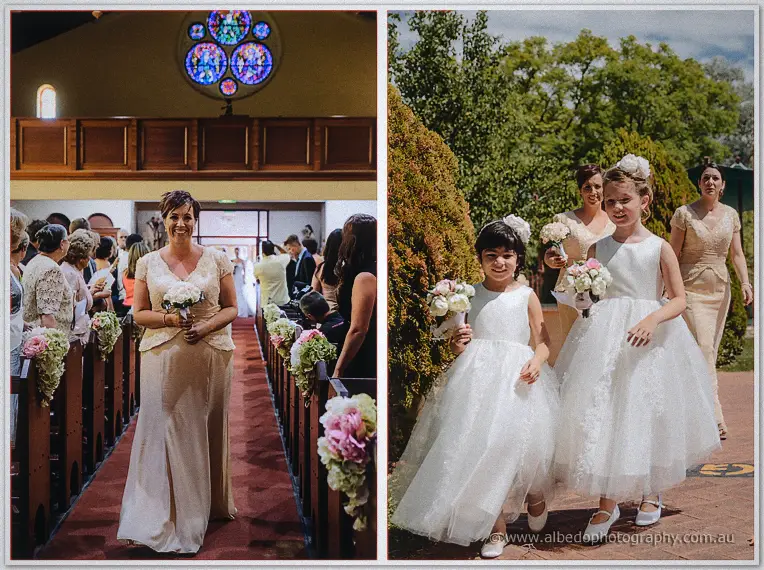 A bridesmaid walks the pew-flower aisle by the rose window, then flower girls lead the way outdoors