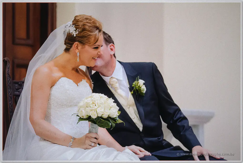 Seated at the sanctuary, Ashley presses a kiss to Kristina's cheek as she laughs
