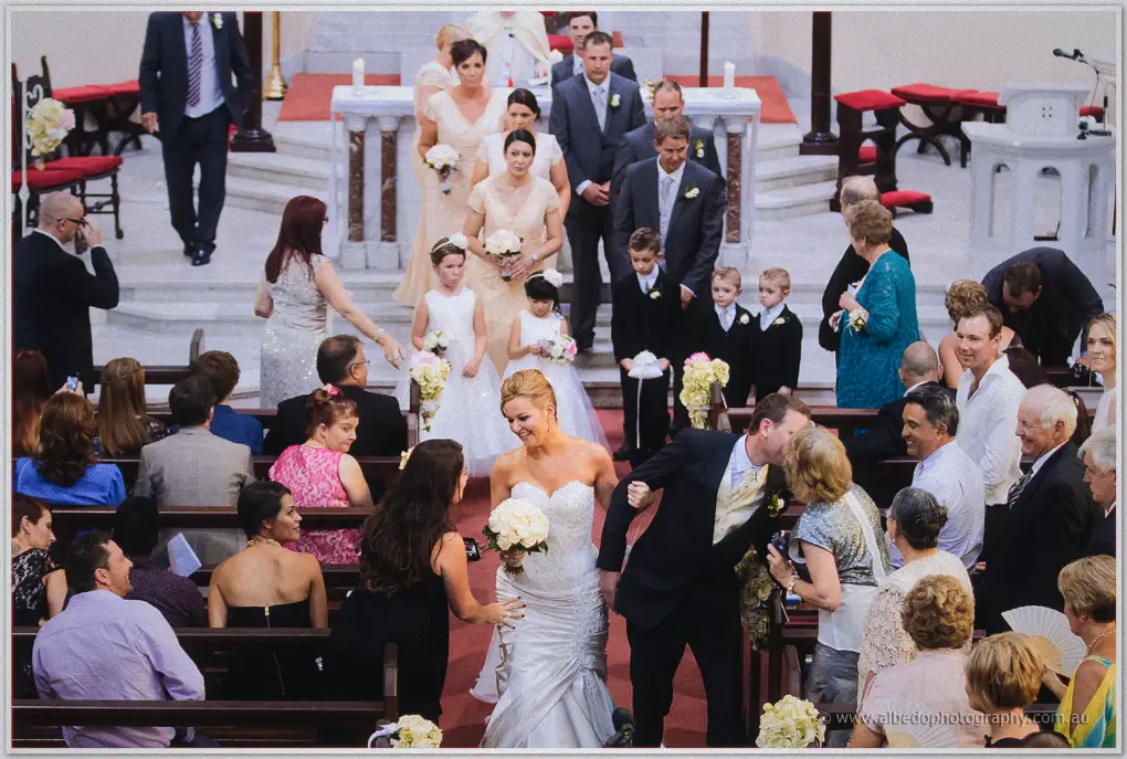 The newlyweds greet guests along the aisle as the bridal party follows from the altar