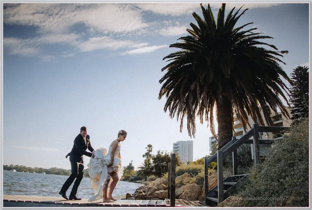 Ashley steadies Kristina as she steps barefoot from the jetty ladder onto the rocks