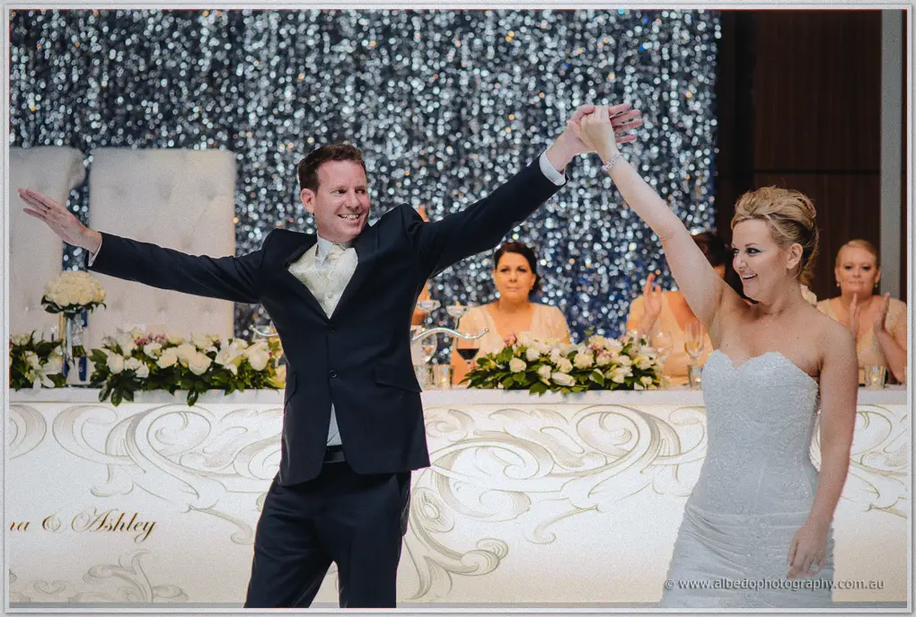 Ashley twirls Kristina with arms flung wide during their first dance in the ballroom
