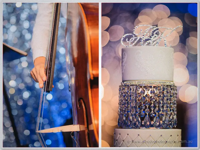 A double bassist plays beneath blue lights as the monogrammed wedding cake catches golden bokeh