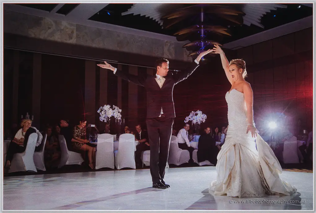 Ashley strikes a dramatic pose as Kristina raises her arm on the white dance floor