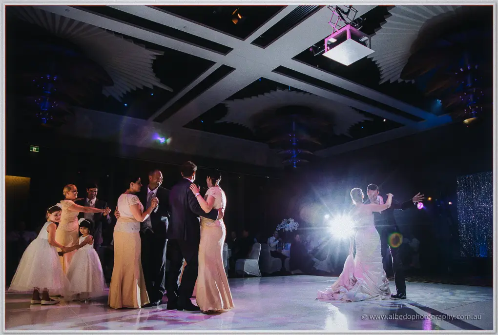 Parents, flower girls and the newlyweds share the dimly lit dance floor at the Astral Ballroom.