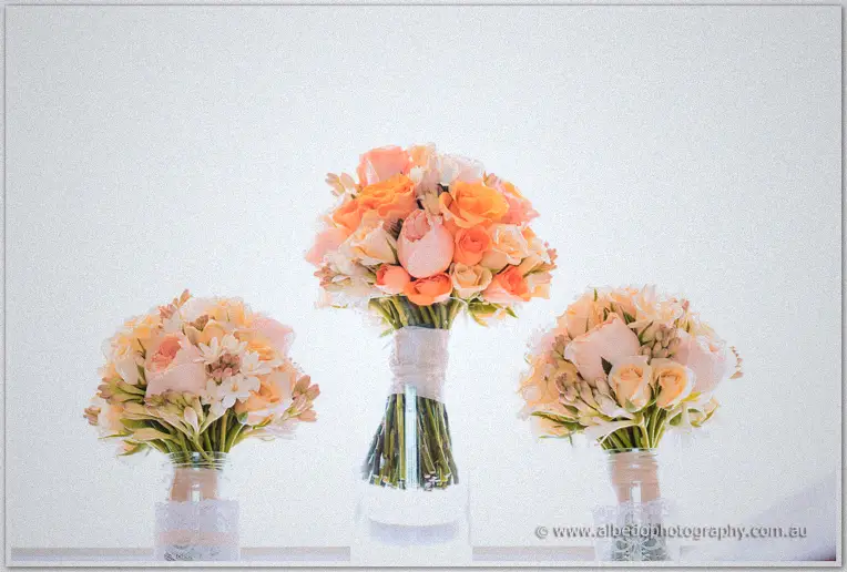 Peach and cream rose bouquets stand in glass jars awaiting Katelyn's vintage Brookleigh celebration