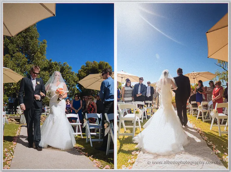 Katelyn and her father walk the petal-strewn aisle toward the arbour