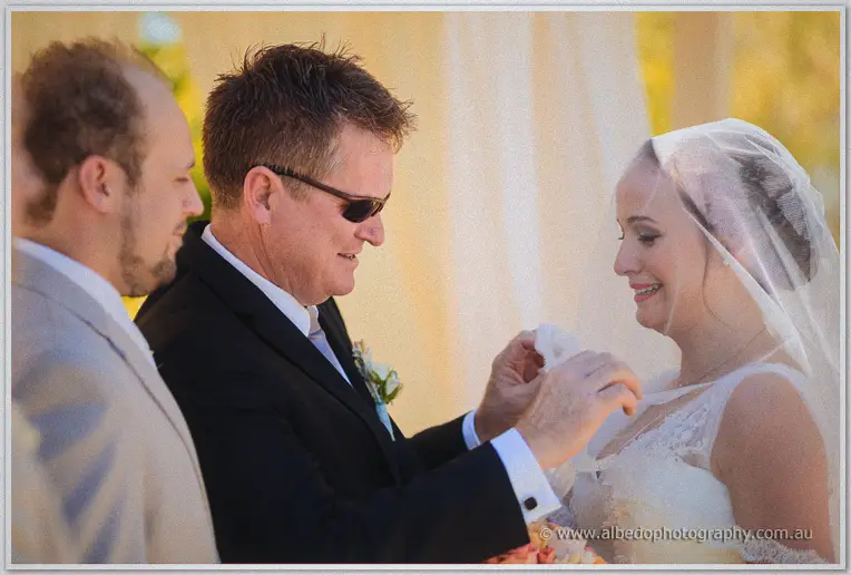 Katelyn's father lifts her veil as the Brookleigh ceremony begins