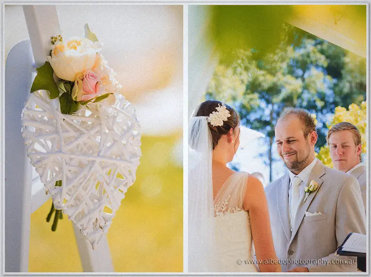 A woven rattan heart blooms with roses beside the couple at the arbour