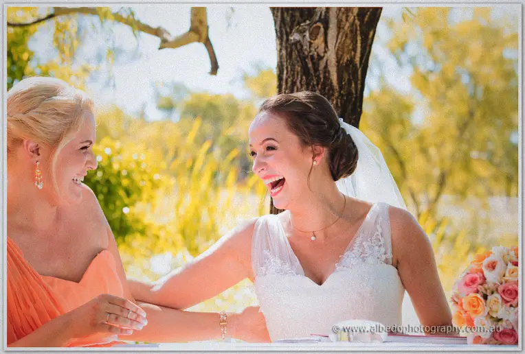 Katelyn and her bridesmaid share a laugh after the signing under the willow