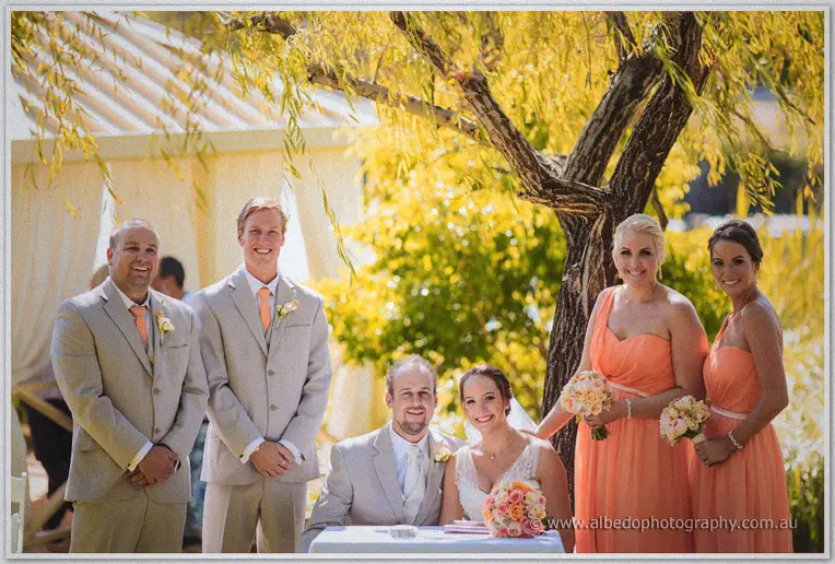 The bridal party gathers around Katelyn and Matt at the signing table
