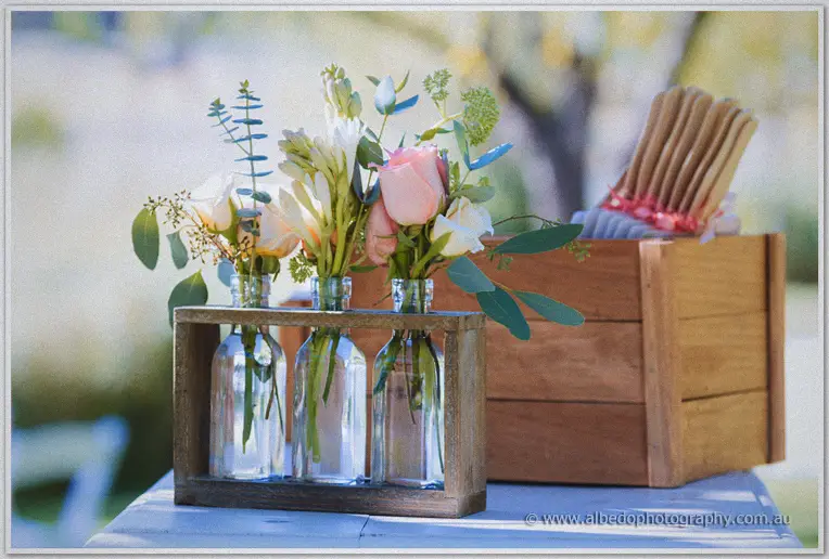 Wildflowers in glass bottles and ribboned fans dress the reception tables at Brookleigh