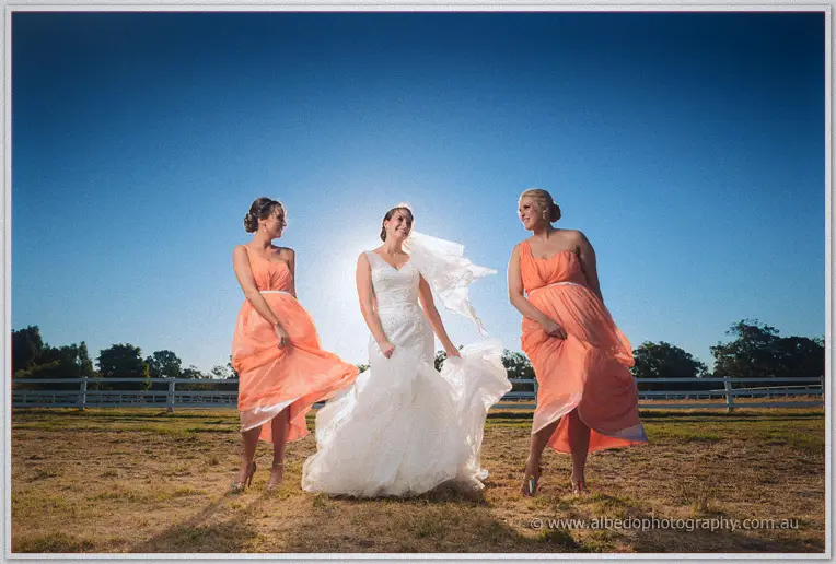 Katelyn and her bridesmaids swinging their gowns in the breeze under a vast blue sky