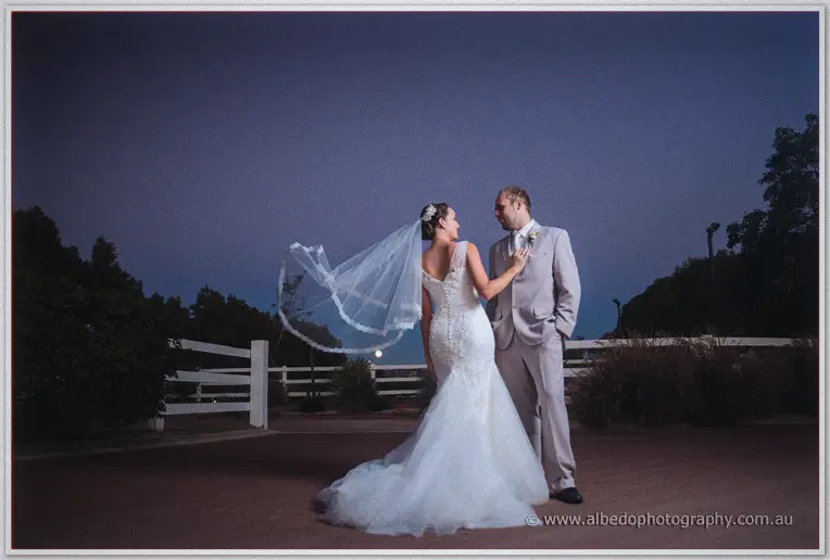 Wind whips Katelyn's veil skyward as she and Matt face each other under a deep blue night sky