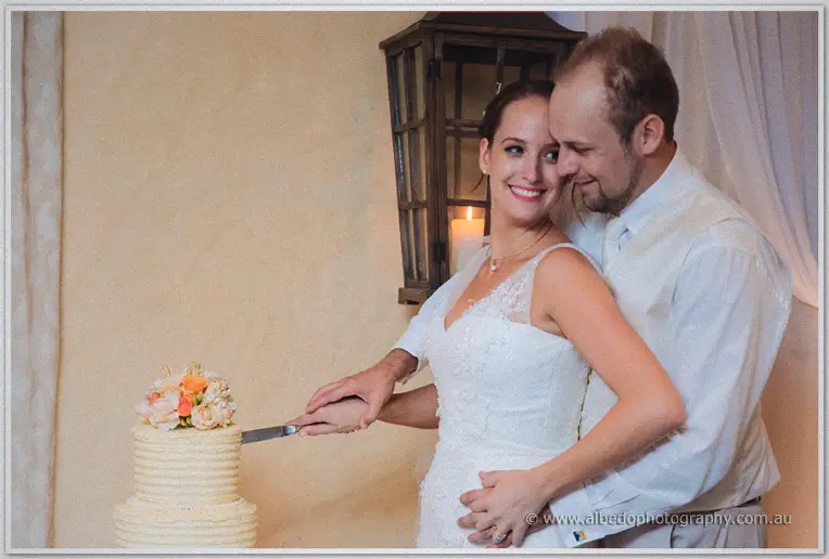 Katelyn and Matt cut their flower-topped cake together under a candle-lit lantern