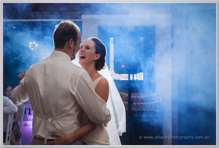 Katelyn laughs mid-spin in Matt's arms as blue fog rolls across the dance floor