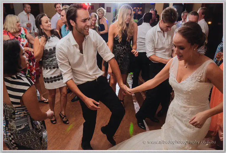 Katelyn spins a guest by the hand on the dance floor amid a crowd of dancers