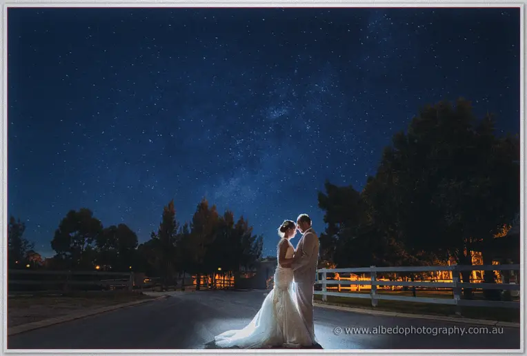 Katelyn and Matt embrace under a starry Swan Valley night sky, lit by a single soft light